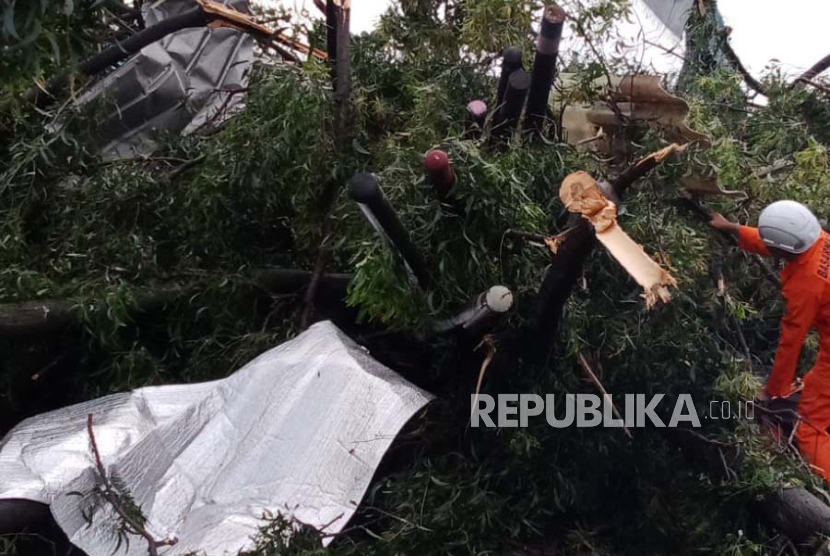 Petugas gabungan melakukan evakuasi material pohon tumbang dan material rumah yang terbawa puting beliung di Jalan Raya Bandung-Garut, Rancaekek, Kabupaten Bandung, Rabu (21/2/2024). 