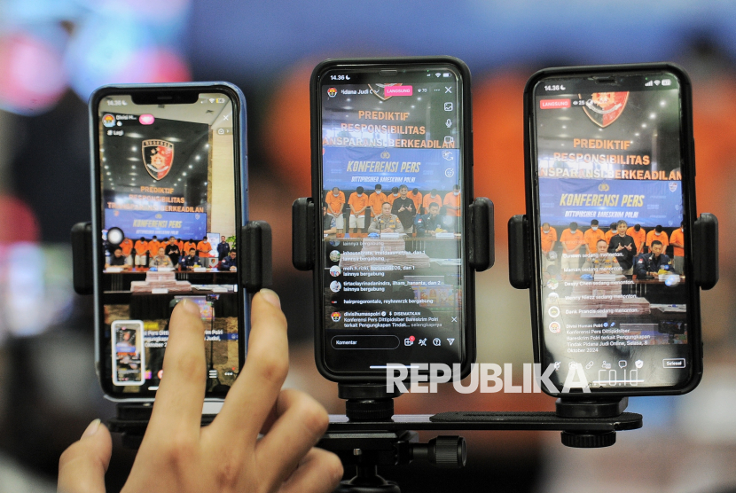 Jurnalus melakukan siaran langsung saat konferensi pers terkait pengungkapan kasus judi online di Bareskrim Polri, Jakarta, Selasa (8/10/2024).