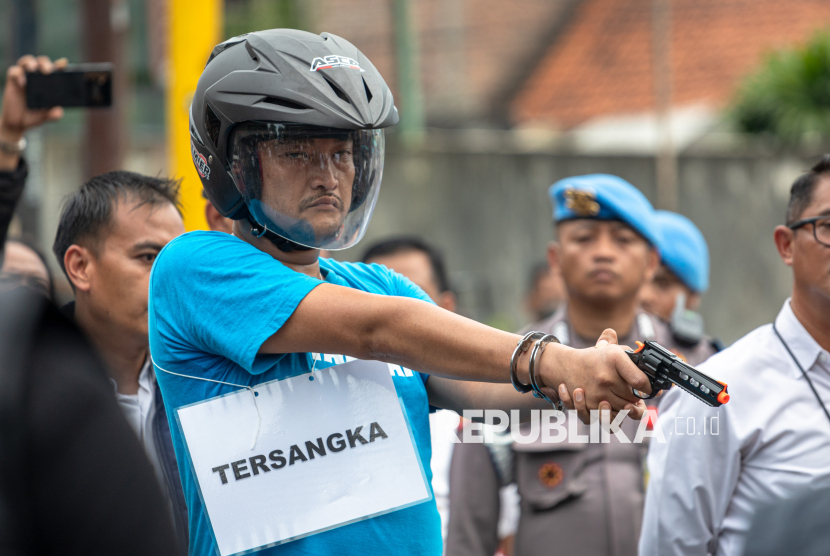 Pelaku penembak pelajar hingga tewas, Aipda Robig Zainudin memperagakan adegan penembakan pelajar saat rekonstruksi kasus di Kelurahan Kalipancur, Kecamatan Ngaliyan, Kota Semarang, Jawa Tengah, Senin (30/12/2024). Ditreskrimum Polda Jateng menggelar 43 adegan rekonstruksi di enam lokasi kejadian dengan menghadirkan Aipda Robig Zainudin sebagai tersangka penembakan dan 11 saksi termasuk almarhum GRO dan satu saksi lain berinisial B yang perannya digantikan, untuk mendapatkan gambaran utuh dari peristiwa penembakan tersebut. 