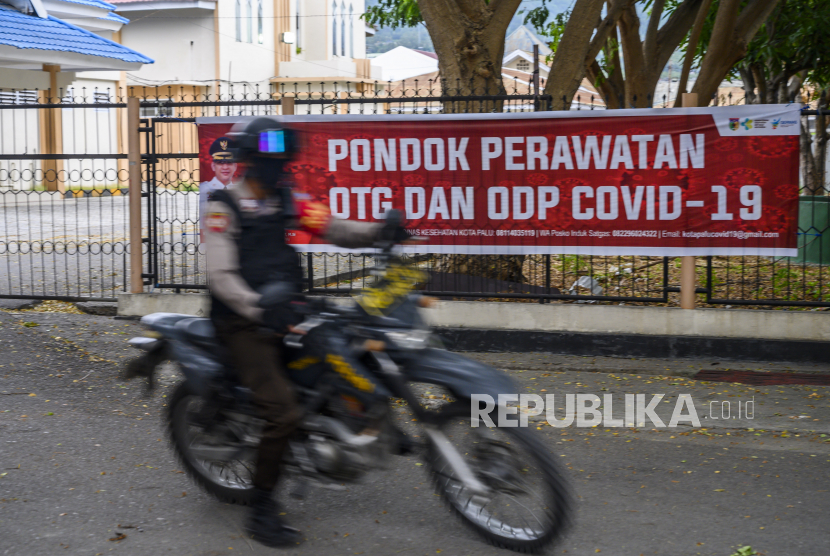 Polisi bersepeda motor melintas di depan Asrama Haji yang dijadikan Pondok Perawatan Orang Tanpa Gejala (OTG) dan Orang Dalam Pemantauan (ODP) COVID-19 di Kota Palu, Sulawesi Tengah, Sabtu (9/5/2020). Gugus Tugas COVID-19 Sulteng mencatat, per 9 Mei 2020, jumlah orang terkonfirmasi positif COVID-19 di Sulawesi Tengah sudah mencapai 75 orang dan Kemenkes telah menetapkan dua wilayah di Sulawesi Tengah sebagai daerah penyebaran transmisi lokal yakni Kota Palu dan Kabupaten Buol