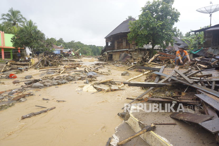 Seorang warga jongkok di atas puing rumah yang rusak akibat terkena banjir bandang di Desa Keban Agung, Kecamatan Mulak Sebingkai, Kabupaten Lahat, Sumatera Selata, Jumat (10/03/2023). (Ilustrasi)