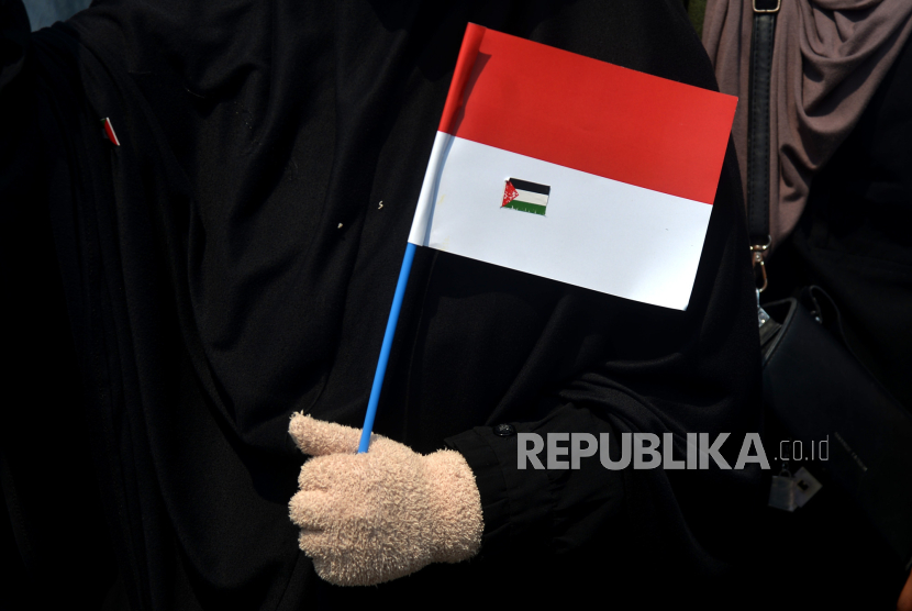 Peserta membawa bendera Indonesia dan Palestina saat mengikuti aksi damai Indonesia Turun Tangan Bantu Palestina, (ilustrasi).