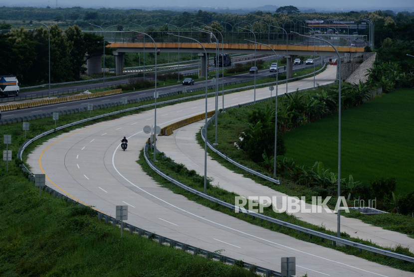 Pengendara motor melintasi area pembangunan Tol Cileunyi-Sumedang-Dawuan (Cisumdawu) seksi 6 di Kabupaten Majalengka, Jawa Barat, Rabu (28/12/2022). Kementerian Keuangan (Kemenkeu) mencatat realisasi Surat Berharga Syariah Negara (SBSN) proyek pada tahun 2022 mencapai Rp 28,78 triliun atau 97,11 persen dari alokasi yang senilai Rp 29,54 triliun. 
