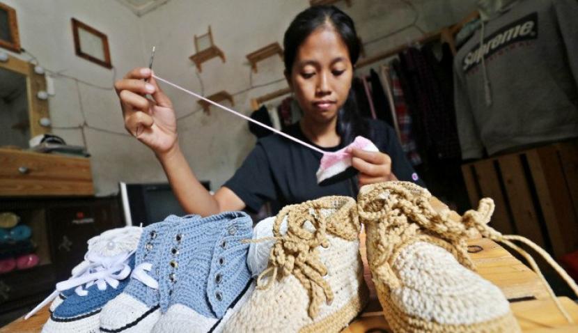 Perajin menyelesaikan pembuatan sepatu rajut untuk balita di Desa Tunglur, Kediri, Jawa Timur, Selasa (11/8/2020). Sepatu rajut seharga Rp30 ribu hingga Rp65 ribu per pasang tergantung jenis dan ukuran tersebut dipasarkan secara daring. (Antara/Prasetia Fauzani)