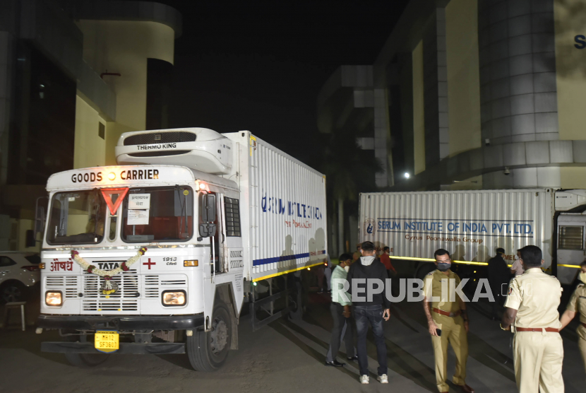 Seorang polisi berjaga di dekat truk kontainer yang membawa kiriman pertama vaksin saat bersiap berangkat ke bandara di Serum Institute of India pembuat vaksin terbesar di dunia, di Pune, India. India mengalami lonjakan kasus Covid pada April ini.