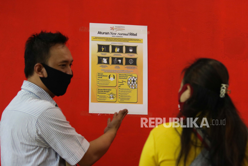 Pegawai swalayan Carrefour menunjukkan poster kepada pengunjung usai ditempel di BG Junction, Surabaya, Jawa Timur, Rabu (27/5). Daerah dinilai terpaksa menerapkan tatanan new normal meski belum siap. (ilustrasi)