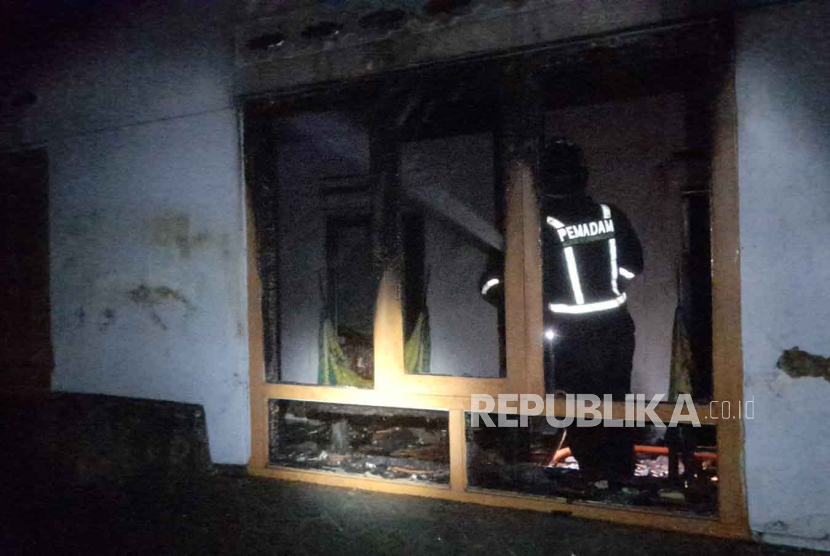 Petugas melakukan pendinginan di rumah warga yang dilanda kebakaran di wilayah Desa Indapatra, Kecamatan Cigandamekar, Kabupaten Kuningan, Jawa Barat, Selasa (19/9/2023) dini hari.