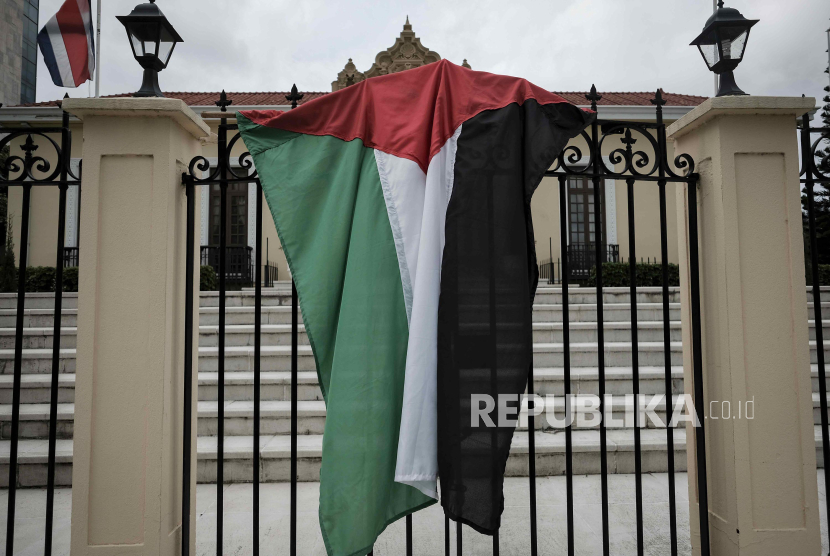 Seorang pengunjuk rasa pro-Palestina memegang bendera di depan Kementerian Luar Negeri di San Jose, Kosta Rika, Selasa (16/7/2024). Para pengunjuk rasa mendesak pemerintah Kosta Rika untuk memutuskan hubungan diplomatik dengan Israel, dengan alasan kematian ribuan anak-anak Palestina di Gaza karena serangan Israel yang sedang berlangsung.