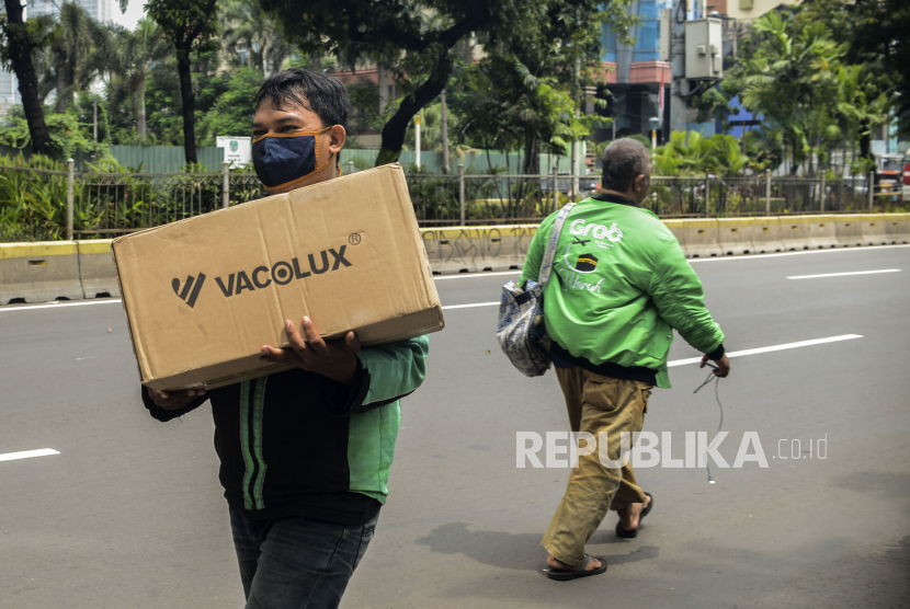 Sejumlah pengemudi ojek online membawa barang pesanan di Jalan Kramat Raya, Senen, Jakarta. Potongan komisi ojek daring (ojol) oleh aplikator sekitar 20 persen per pengemudi diusulkan untuk diturunkan.