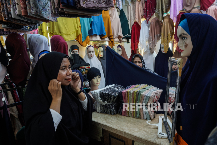 Calon pembeli mencoba jilbab yang dijual di salah satu toko di Pasar Tanah Abang, Jakarta, Sabtu (18/11/2023).  