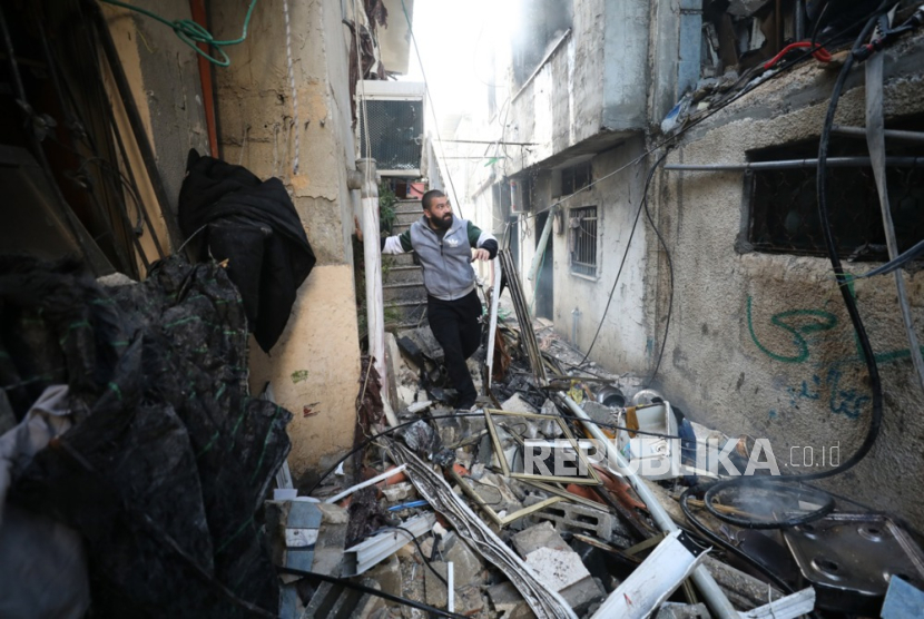 Seorang warga memeriksa kerusakan setelah tentara Israel menghancurkan sebuah rumah menyusul penggerebekan di kamp pengungsi Al Nur Shams dekat kota Tulkarem, Tepi Barat, 26 Desember 2023. 