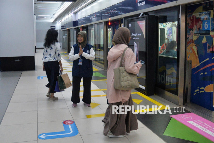 Pekerja lanjut usia (lansia) menyapa pengguna MRT Jakarta di Stasiun Bundaran HI, Jakarta, Selasa (3/6/2025).