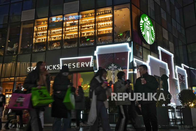 Pengunjung melintasi gerai kopi Starbucks di kompleks pusat perbelanjaan di Beijing, Cina, 23 Desember 2023. 