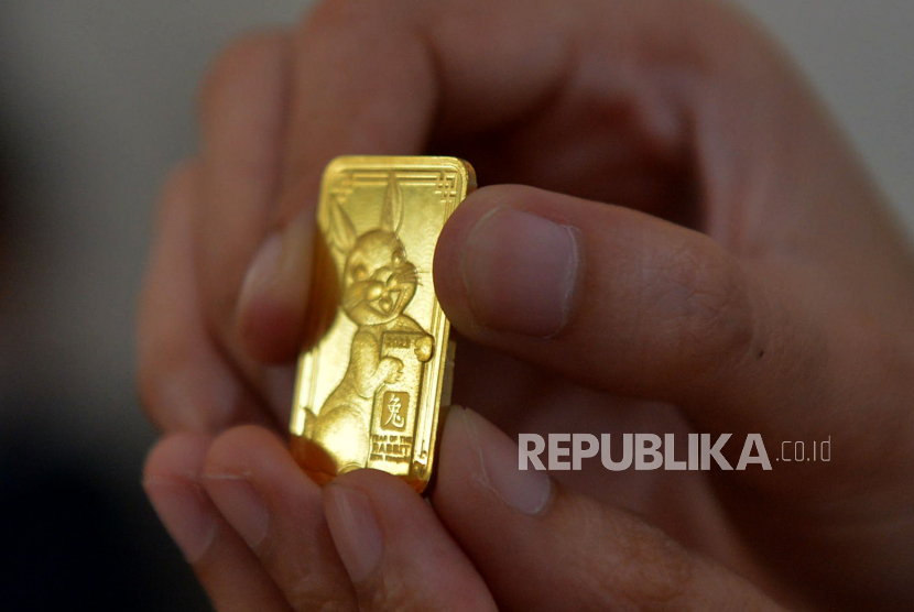 Petugas menunjukan emas batangan edisi imlek 2023 di Butik Emas Antam, Pulogadung , Jakarta, Senin (16/1/2023). Harga emas batangan dari Logam Mulia PT Aneka Tambang Tbk (Antam) mengalami kenaikan pada Jumat (24/3/2023). 