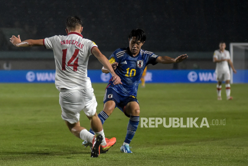 Pemain Timnas Jepang U17 Yoshinaga Yumeki (kanan) berebut bola dengan pemain Timnas Polandia U-17 Skoczylas Mateusz (kiri) pada babak penyisihan Grup D Piala Dunia U-17 2023 di Stadion Si Jalak Harupat, Soreang, Kabupaten Bandung, Sabtu (11/11/2023).
