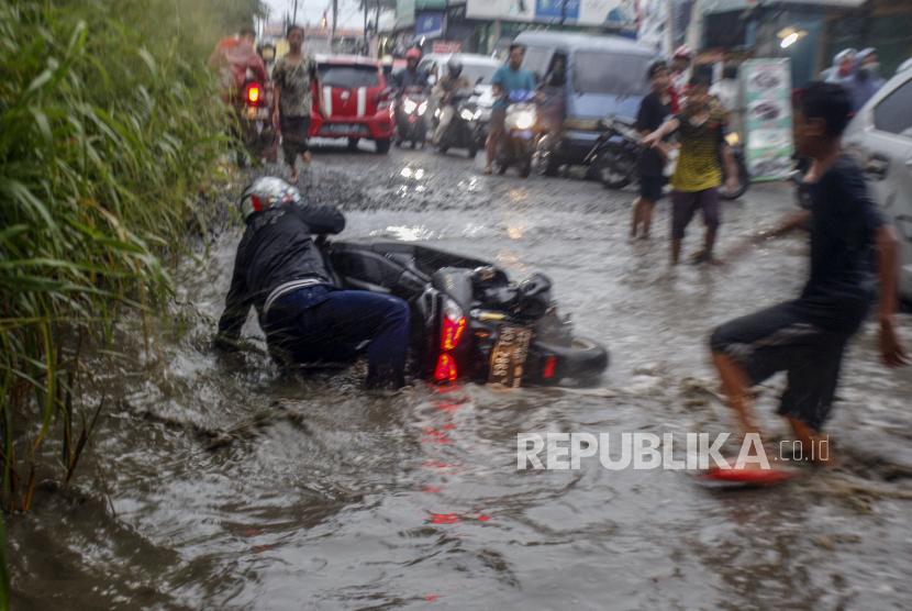 Pengendara sepeda motor terjatuh saat melintasi Jalan Raya Bojong Gede-Citayam yang banjir di Bojong Gede (ilustrasi)