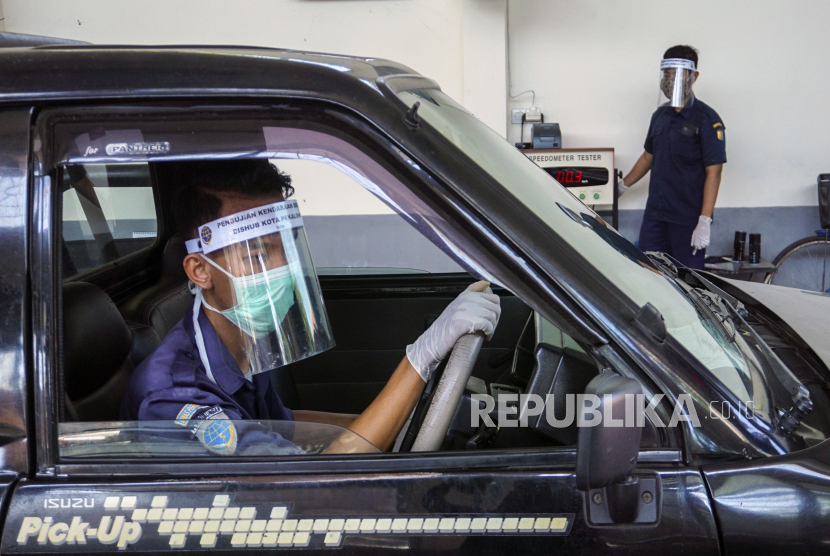 Petugas menggunakan pelindung wajah saat menguji kir kendaraan di Dinas Perhubungan.