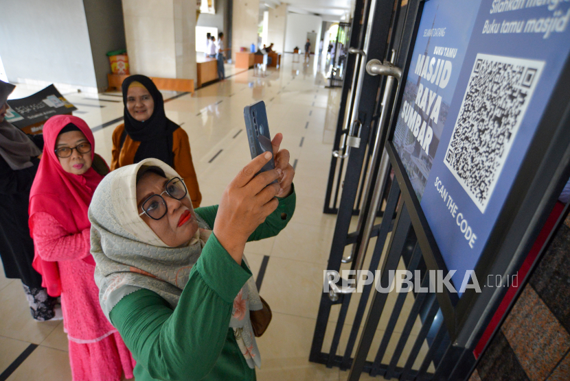 Pengunjung memindai QR code untuk mengisi buku tamu di Masjid.