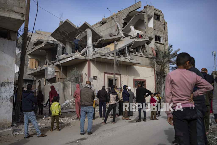 Warga Palestina mencari jenazah di sebuah rumah yang terkena serangan Israel di Rafah, Jalur Gaza pada Rabu, (27/3/2024).