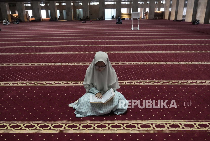 Seorang wanita Muslim membaca Alquran di Masjid Istiqlal di Jakarta, Indonesia, Selasa, 5 April 2022.  4 Cara Melatih Otak untuk Membiasakan Membaca Alquran