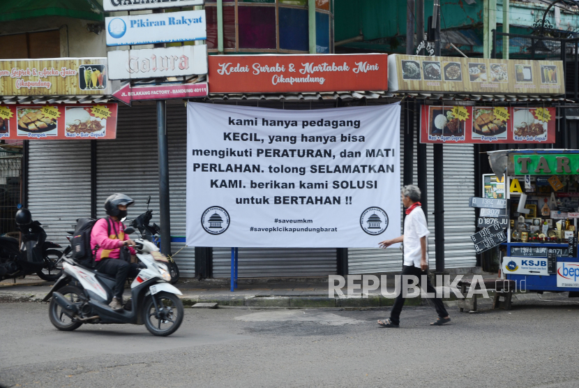 Sejumlah spanduk dipasang oleh Paguyuban Pedagang Kaki Lima terkait dampak PPKM yang dirasakan para pedagang kaki lima (PKL) di Jalan Cikapundung Bandung Barat, Kota Bandung, Jumat (16/7). Spaduk tersebut berisi harapan kepada pemerintah agar ada kebijakan dan solusi untuk mengatasi masalah yang dihadapi para pedagang kecil seperti PKL di saat penerapan PPKM Darurat.