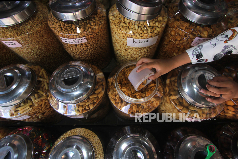 Pedagang kue kering melayani konsumen di Pasar Sudimampir, Banjarmasin, Kalimantan Selatan, Senin (4/5/2020). Menurut pedagang, omzet menjelang lebaran tahun ini anjlok hingga 50 persen dari tahun sebelumnya dikarenakan pembatasan jam operasional pasar di tengah pandemi COVID-19