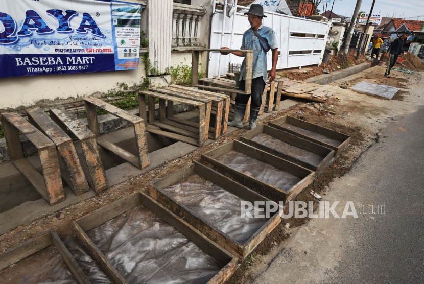 Sejumlah pekerja menyelesaikan pembuatan irigasi yang dibiayai program Padat Karya Tunai (PKT) Kementrian PUPR di Jalan Amin Jasuta, Serang, Banten, awal Mei lalu. Kementerian PUPR juga mendorong program yang sama segera berjalan di Kalimantan Tengah.