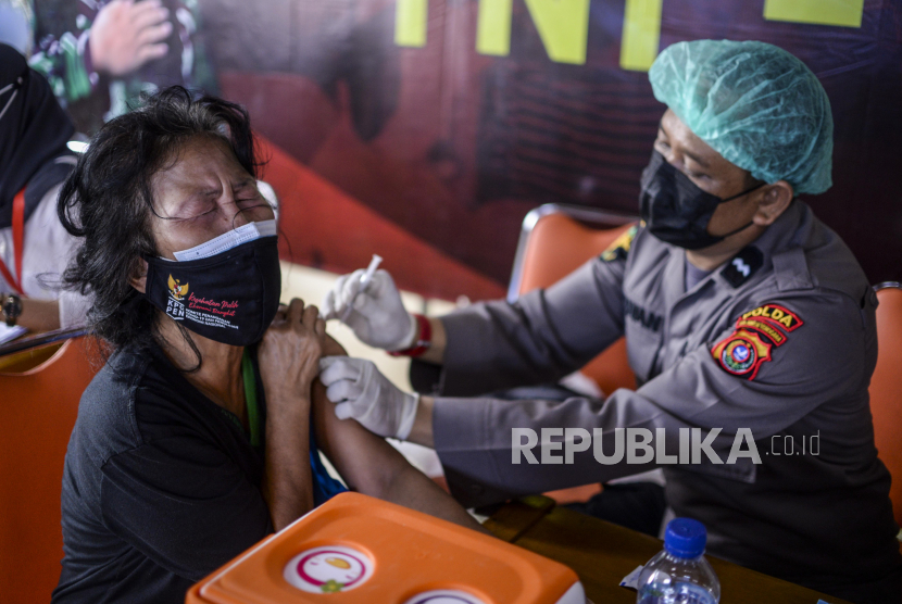 Polisi menyuntikan vaksin Covid-19 kepada warga di RPTRA Rusun Petamburan, Tanah Abang, Jakarta, Kamis (22/7). Kegiatan vaksinasi Covid-19 itu menyasar daerah pemukiman padat penduduk yang rentan dari penularan Covid-19. Republika/Putra M. Akbar