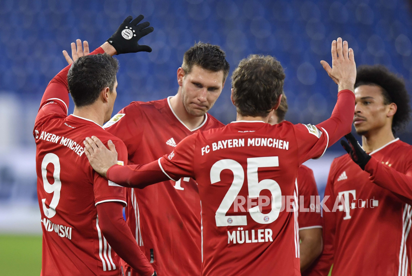 Robert Lewandowski dari Bayern (kiri) merayakan dengan rekan setimnya setelah mencetak gol selama pertandingan sepak bola Bundesliga Jerman antara FC Schalke 04 dan Bayern Munich di Gelsenkirchen, Jerman, Minggu, 24 Januari 2021. 