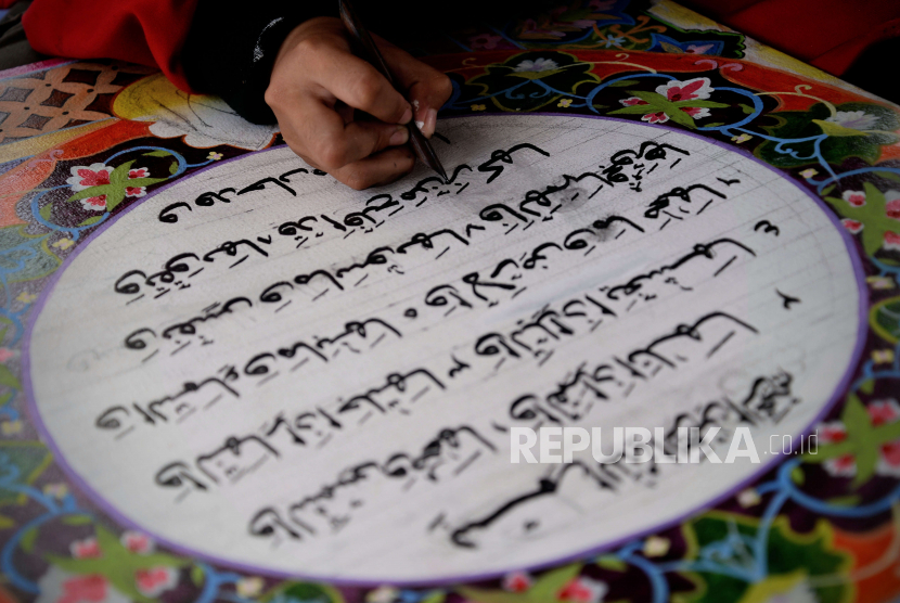 Pelajar menyelesaikan lukisan kaligrafi saat pameran seni kaligrafi.