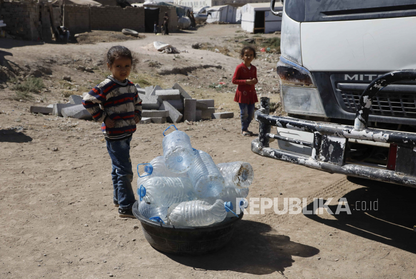  Anak-anak Yaman berdiri di dekat botol air kosong di dekat tangki sumbangan di sebuah kamp Pengungsi Internal (IDP) di pinggiran Sana