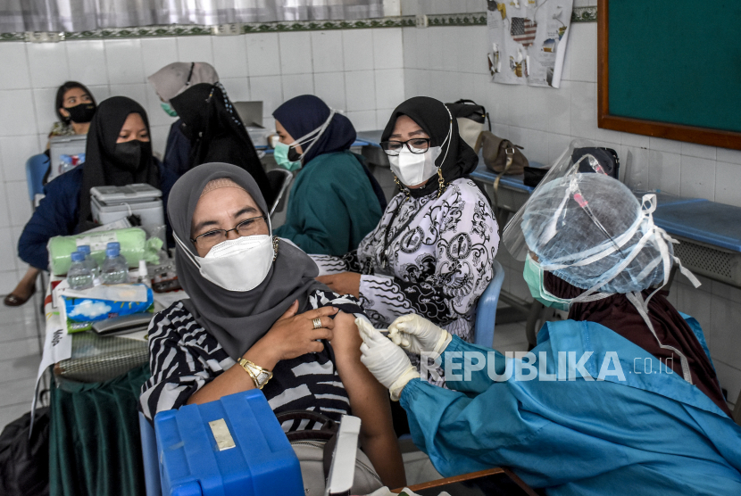 Vaksinator menyuntikan vaksin Covid-19 ke guru dan tenaga pendidik di SMPN 2 Bandung (ilustrasi)