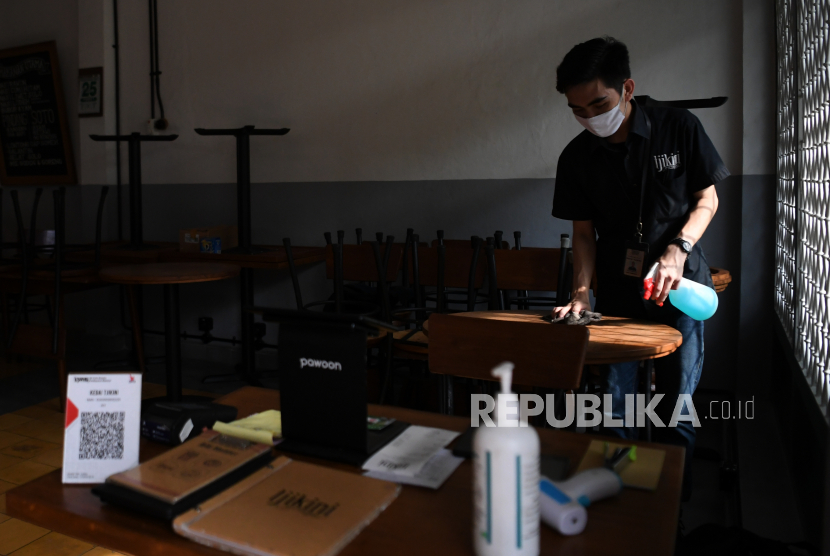Pekerja bekerja di kafe yang sementara tidak melayani makan di tempat karena pemberlakuan Pembatasan Sosial Berskala Besar (PSBB) di Jakarta.