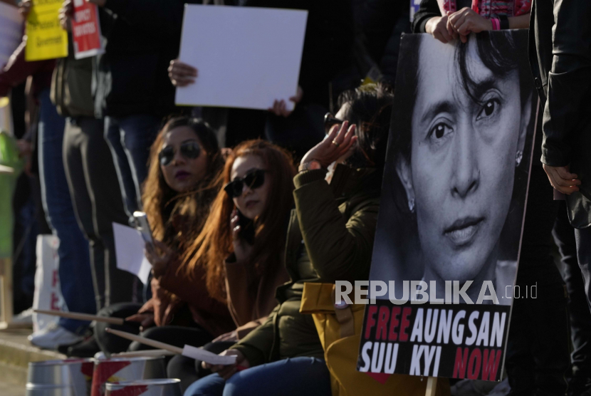 Pengunjuk rasa pro demokrasi Myanmar memegang poster yang menunjukkan wajah politisi Myanmar Aung Sang Suu Kyi, saat mereka memperingati satu tahun perebutan kekuasaan oleh militer di Parliament Square, London, Selasa, 1 Februari, 2022. Aktivis demokrasi Myanmar akan dieksekusi mati setelah permohonan bandingnya ditolak.