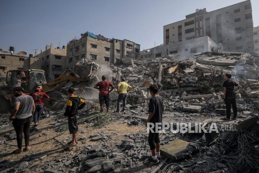 Warga Palestina mencari jenazah dan penyintas di antara puing-puing rumah keluarga Al Shawa yang hancur akibat serangan udara Israel di Gaza, Palestina, Rabu (25/10/2023). 
