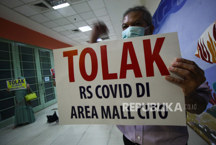 Sejumlah orang yang mengatasnamakan Perkumpulan Penghuni Pemilik dan Pedagang (P4) Cito melakukan aksi bentang poster di City of Tomorrow (Cito) Mall, Surabaya, Jawa Timur,  Rabu (3/2/2021). Mereka menolak rencana pembukaan rumah sakit rujukan bagi pasien COVID-19 yang berada di dekat mall tersebut. 