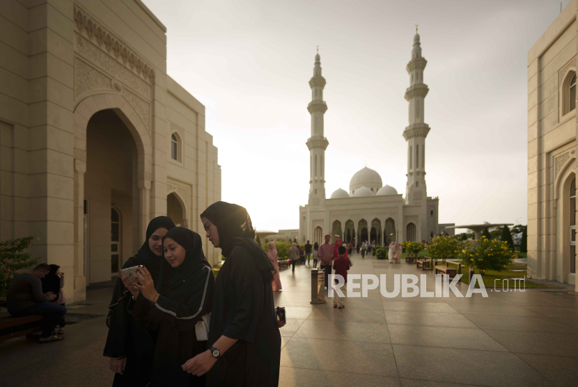 Wanita Muslim melihat foto mereka di ponsel selama bulan suci Ramadhan di luar masjid Sri Sendayan di negara bagian Negeri Sembilan, Malaysia, Sabtu, 16 Maret 2024.