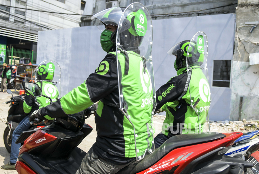Pengemudi ojek daring mengenakan sekat pelindung saat menunggu penumpang di kawasan Jalan Kendal, Jakarta, Rabu (10/6/2020).