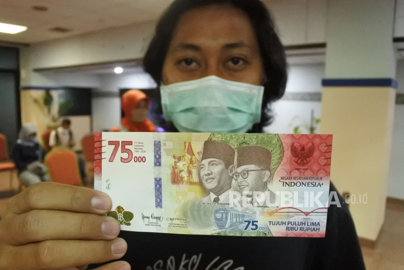 Warga menunjukkan uang baru pecahan Rp75.000 yang merupakan Uang Peringatan Kemerdekaan 75 Tahun Republik Indonesi. ilustrasi