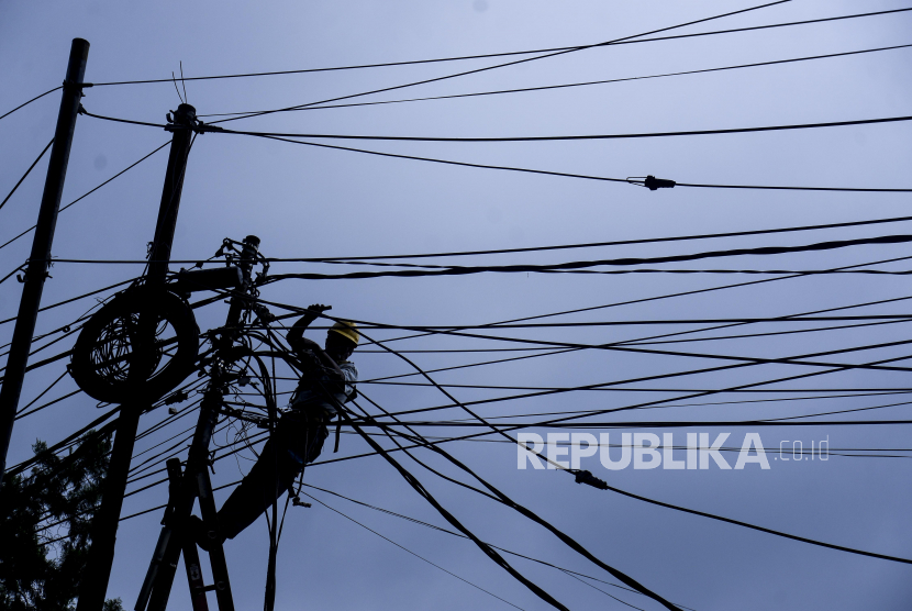 Petugas PLN memperbaiki jaringan kabel listrik yang menjuntai ke jalan di Jalan Pemuda, Kota Bogor, Jawa Barat, Jumat (27/1/2023). PLN membukukan laba bersih yang meroket 199,33 persen year on year (yoy) menjadi senilai Rp 16,04 triliun pada kuartal I 2023.