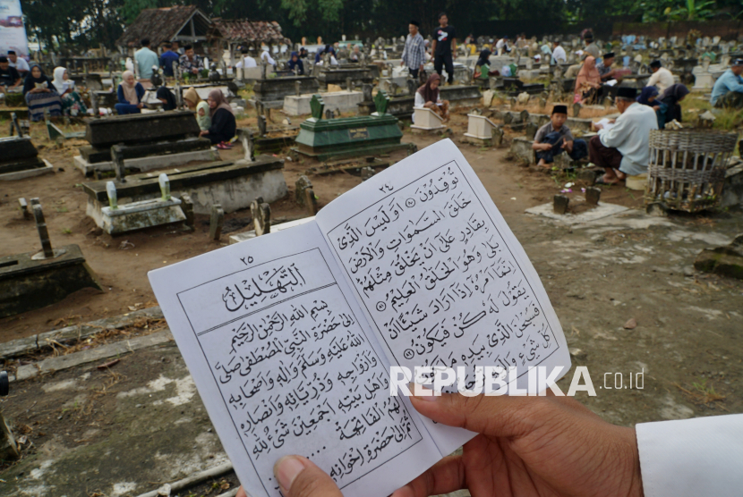 Warga membaca tahlil di pemakaman umum Desa Karanganom, Trenggalek Jawa Timur, Ahad (23/2/2025). Ritual ziarah kubur berjamaah tersebut ditujukan untuk mendoakan arwah leluhur atau anggota keluarga yang sudah meninggal menjelang Bulan Suci Ramadhan. 