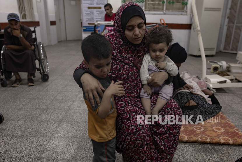 Anak-anak dan seorang wanita menunggu untuk menerima perawatan di Rumah Sakit Al-Najjar menyusul serangan udara Israel yang menghantam rumah mereka di Gaza selatan di Rafah, Jalur Gaza selatan. 