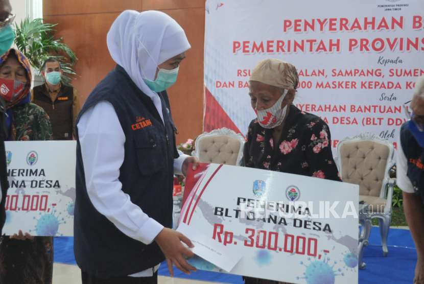  Gubernur Jawa Timur Khofifah Indar Parawansa (kiri) menyerahkan Bantuan Langsung Tunai Dana Desa (BLT DD) kepada warga, di kantor Bakorwil Pamekasan, Jawa Timur,  (ilustrasi)