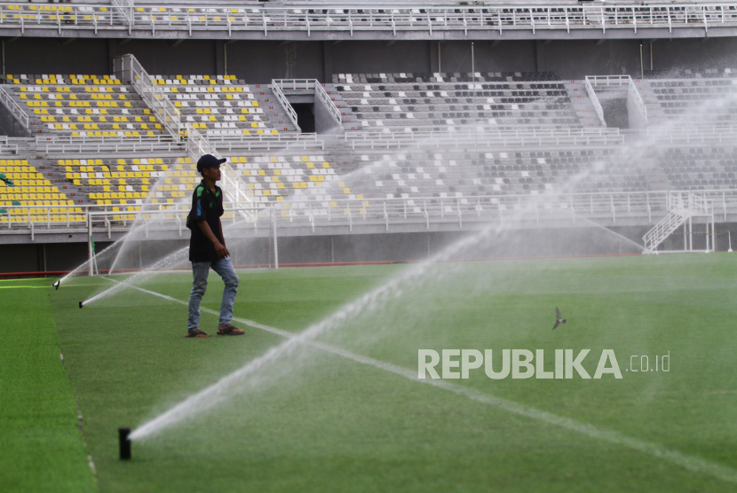 Pekerja mengawasi proses penyiraman lapangan di Stadion Gelora Bung Tomo, Surabaya, Jawa Timur. 