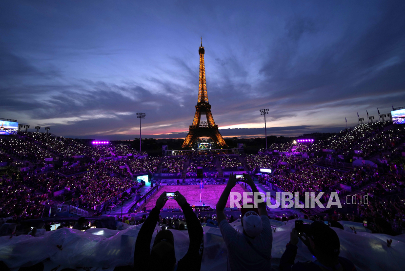 Penonton mengabadikan momen dalam pertandingan voli pantai Olimpiade 2024 di Paris, Prancis, Sabtu (27/7/2024).