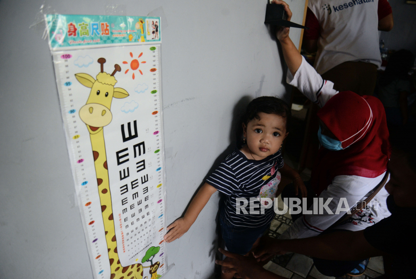 Petugas mengukur tinggi badan anak sebelum disuntikan vaksin campak rubella di kawasan Batu Ampar, Kramat Jati, Jakarta, Selasa (9/8/2022). Stunting harus dicegah saat usia anak kurang dari dua tahun. 