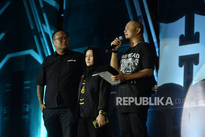 Personel Burgerkill, Agung Hellfrog (kanan) bersama Bubu Anggi Pratiwi, istri dari almarhum gitaris Burgerkill Aries Tanto atau Ebenz (tengah) saat menerima penghargaan Lifetime Achievement untuk Ebenz pada gelaran Hammersonic 2023 di Pantai Karnaval Ancol, Jakarta Utara, Sabtu (18/3/2023) malam.