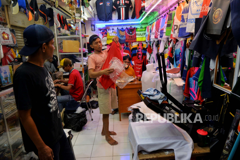 Pedagang menyelesaikan pembuatan kaos alat peraga kampanye partai politik di salah satu kios di Pasar Senen, Jakarta, Selasa (16/5/2023).