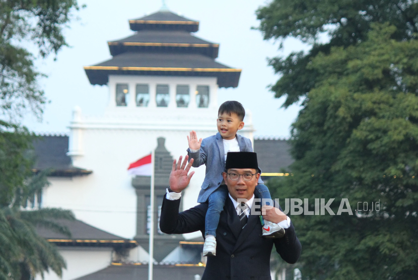 Ridwan Kamil sambil mengendong anak bungsunya Arkana Aidan Misbach berjalan-jalan di Lapangan Gasibu. Ridwan Kamil mengaku dapat penugasan maju di Pilgub DKI dan Jawa Barat.