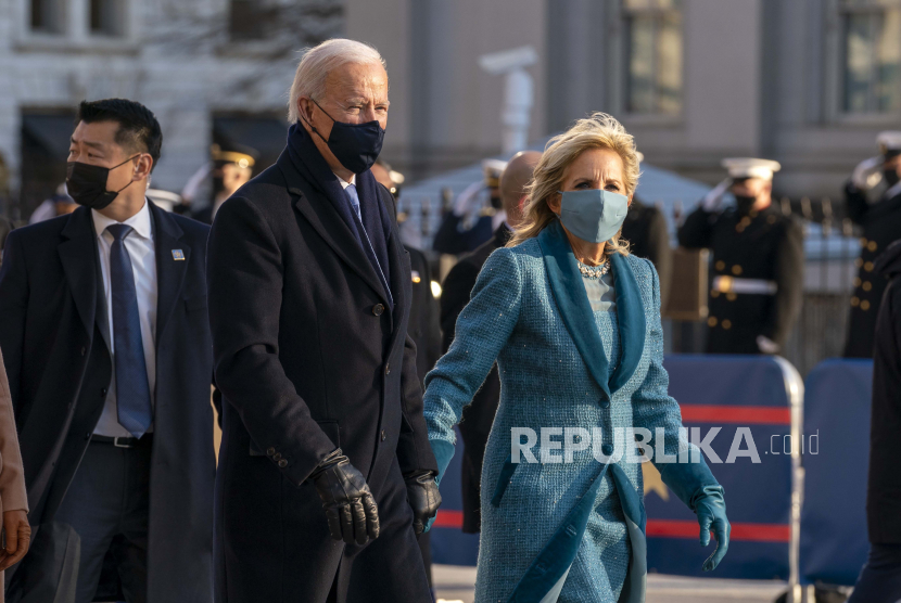 Presiden Joe Biden dan Ibu Negara Jill Biden, berjalan di dekat Gedung Putih saat Pengawalan Presiden ke Gedung Putih, Rabu (20/1/2021) di Washington.